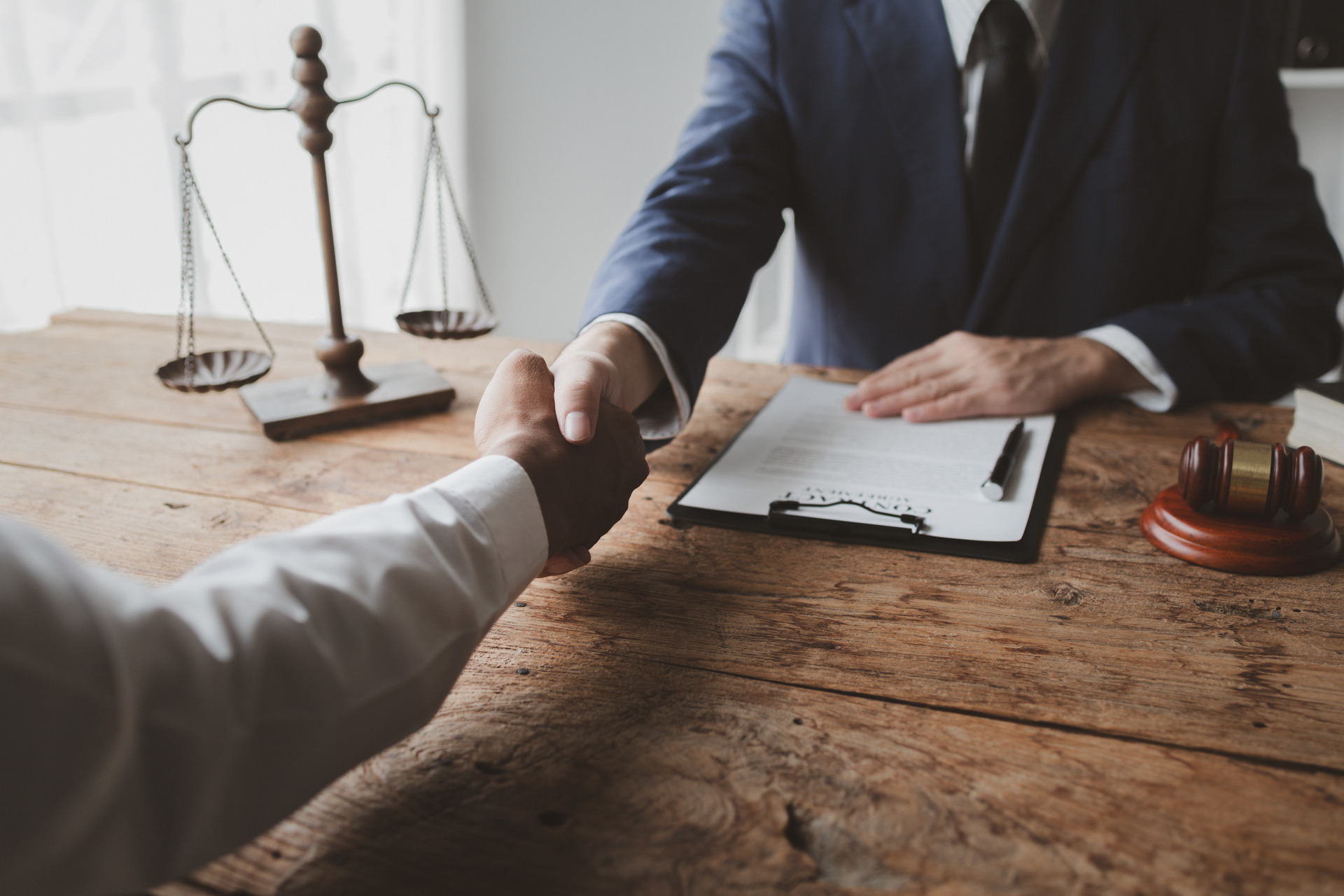 Handshake at lawyer’s office with contract Handshake at lawyer’s office with contract