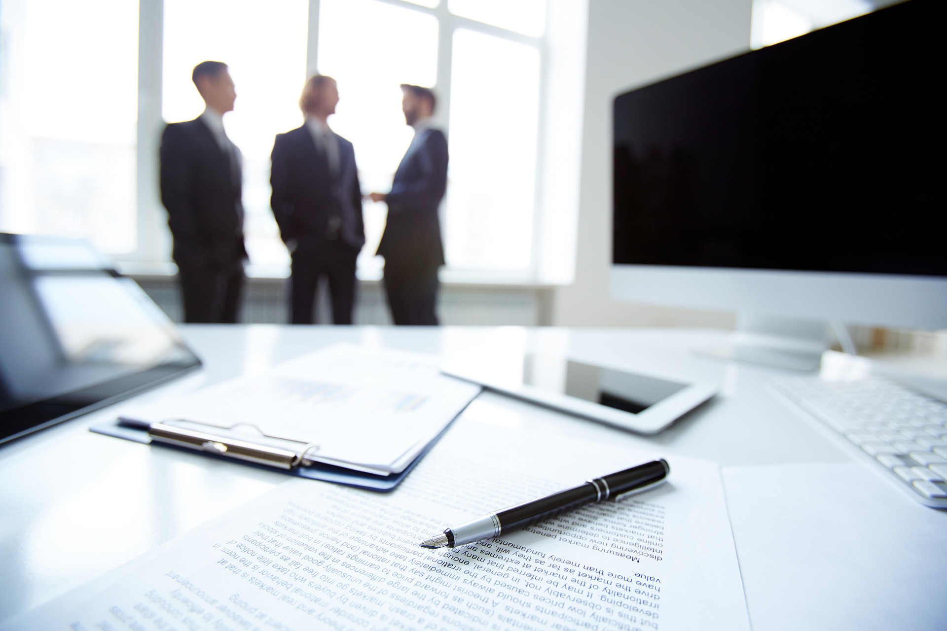 Legal documents on desk with people talking in background Legal documents on desk with people talking in background