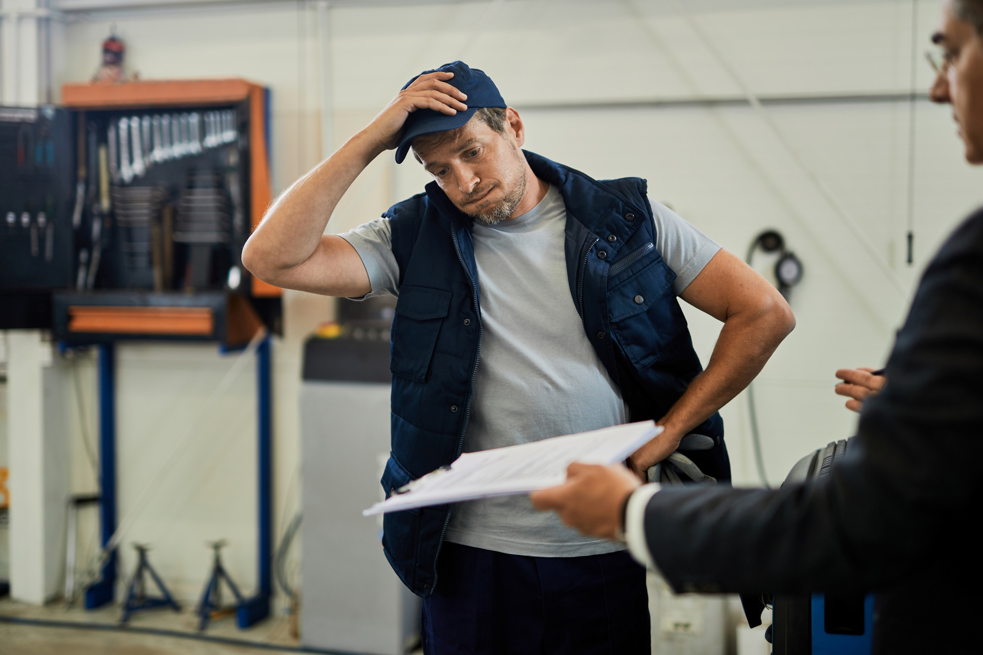 Mechanic looking stressed over paperwork Mechanic looking stressed over paperwork