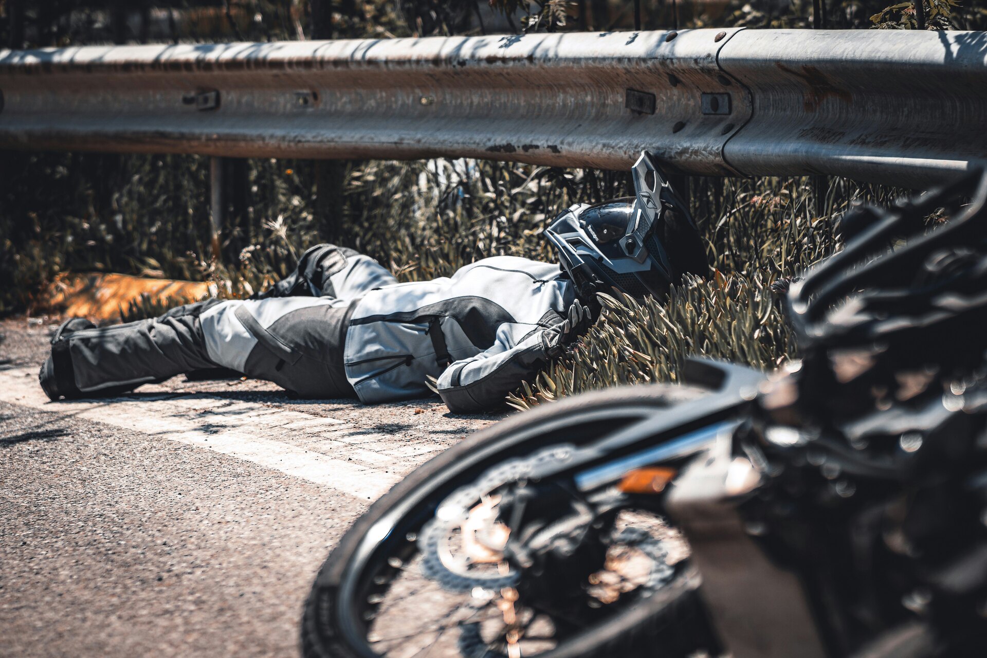 A man is lying on the ground and he fell off the motorcycle A man is lying on the ground and he fell off the motorcycle