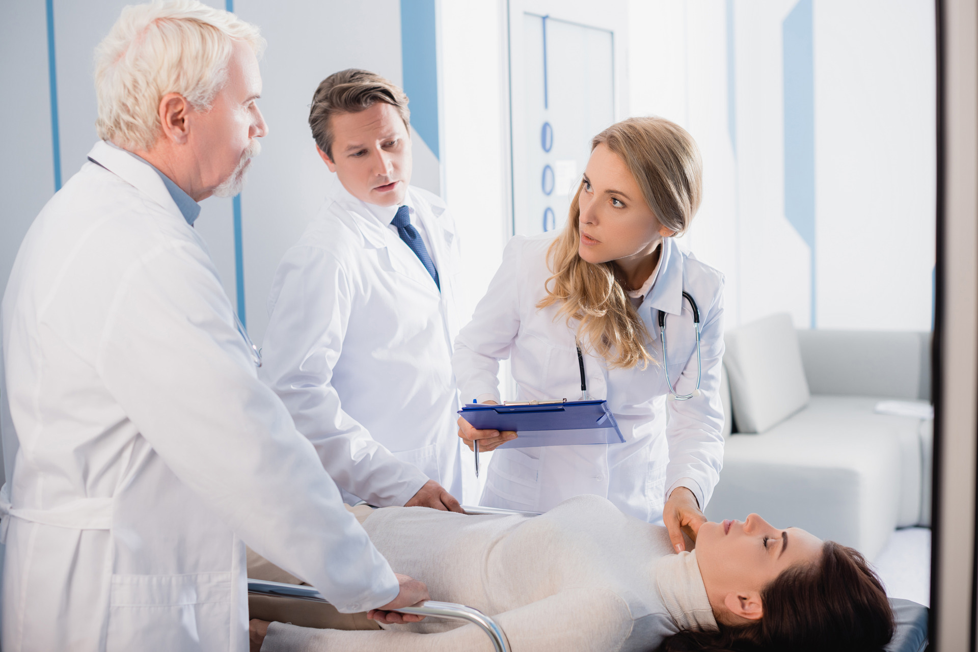 selective focus of doctor with clipboard checking patient selective focus of doctor with clipboard checking patient