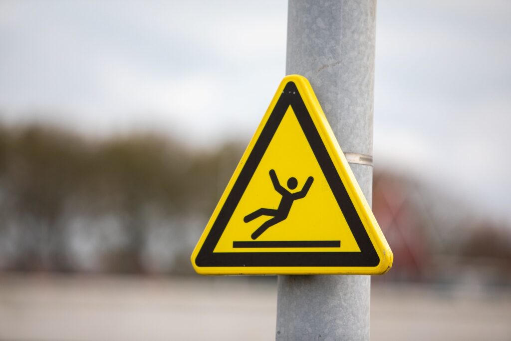 Yellow caution sign warning of slippery surface on pole
