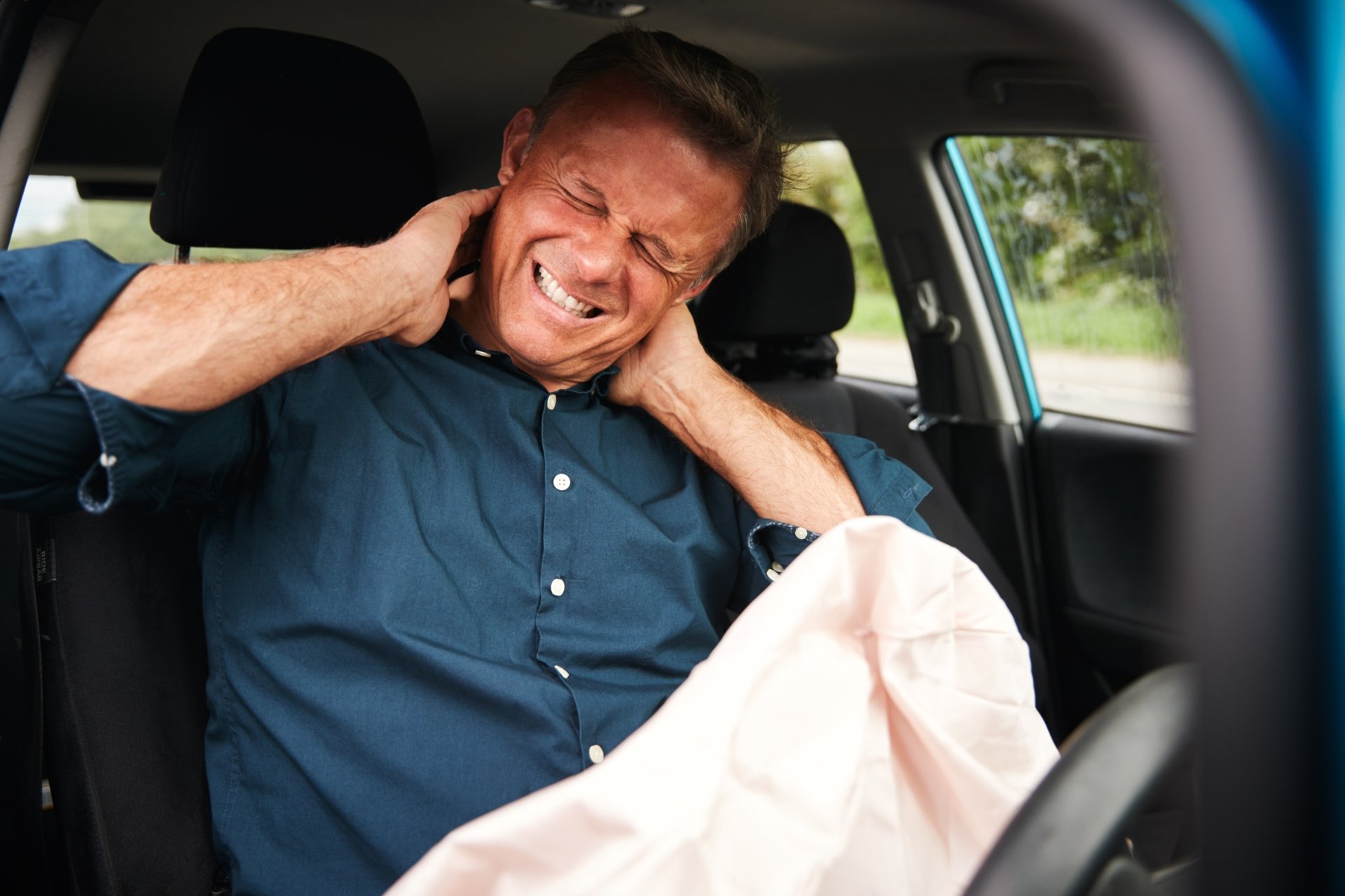 Man in pain holding his neck after a car accident inside his vehicle Man in pain holding his neck after a car accident inside his vehicle