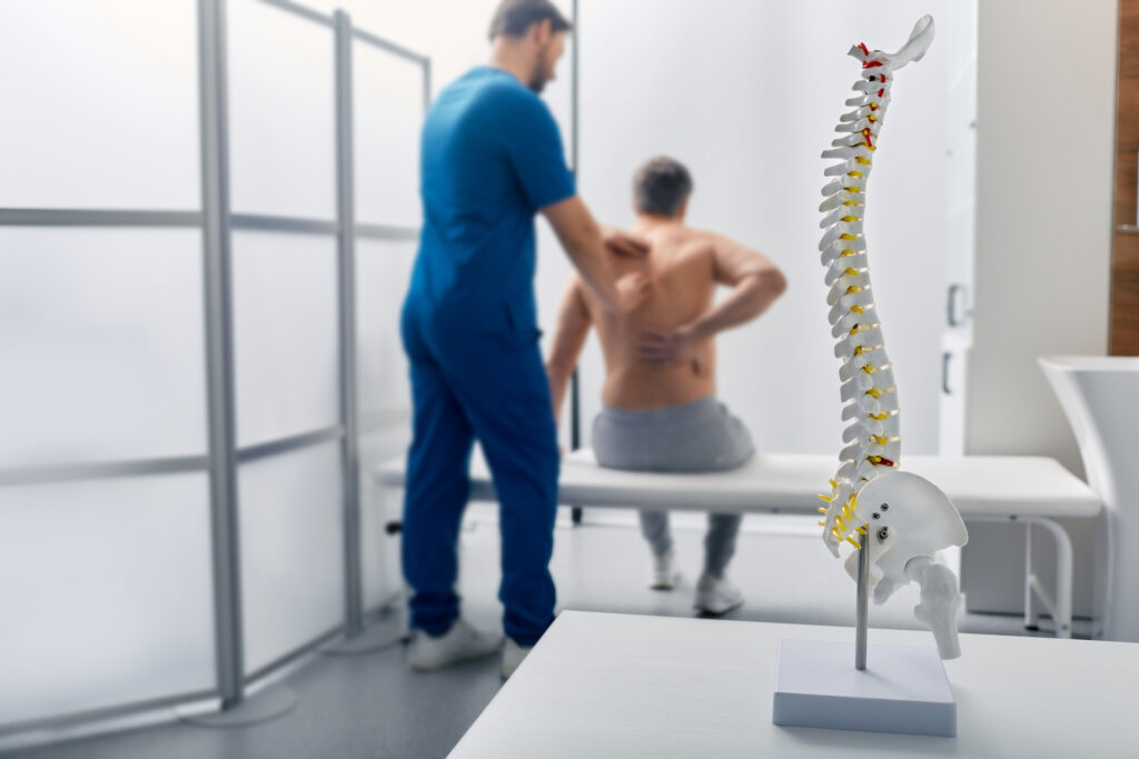 doctor helping patient with back pain