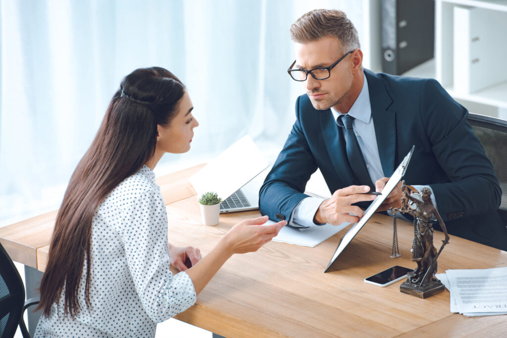 male lawyer pointing at clipboard and speaking with client