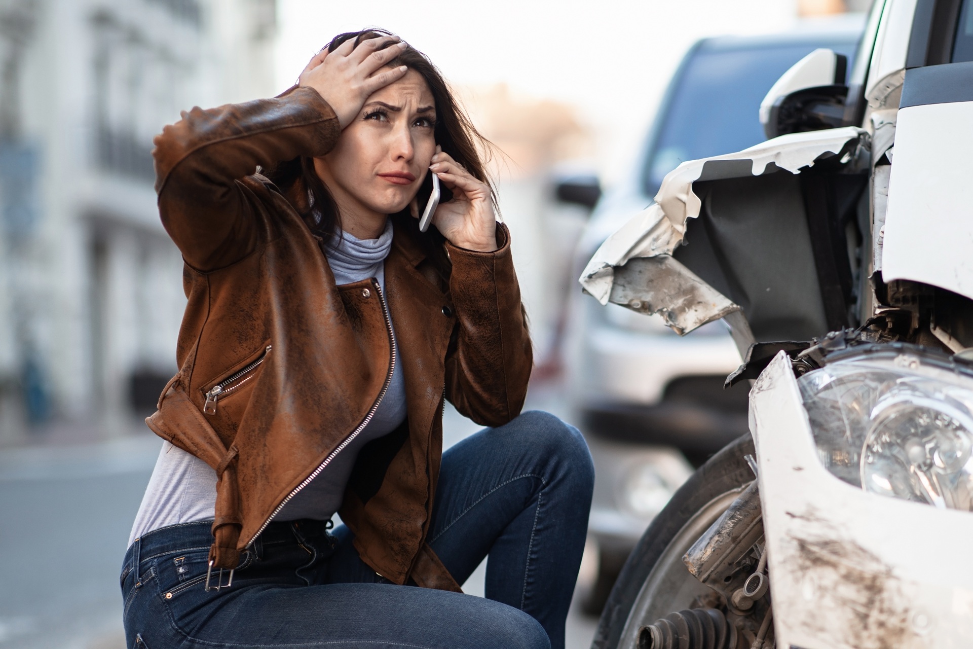 A distressed woman cries while talking on a cell phone