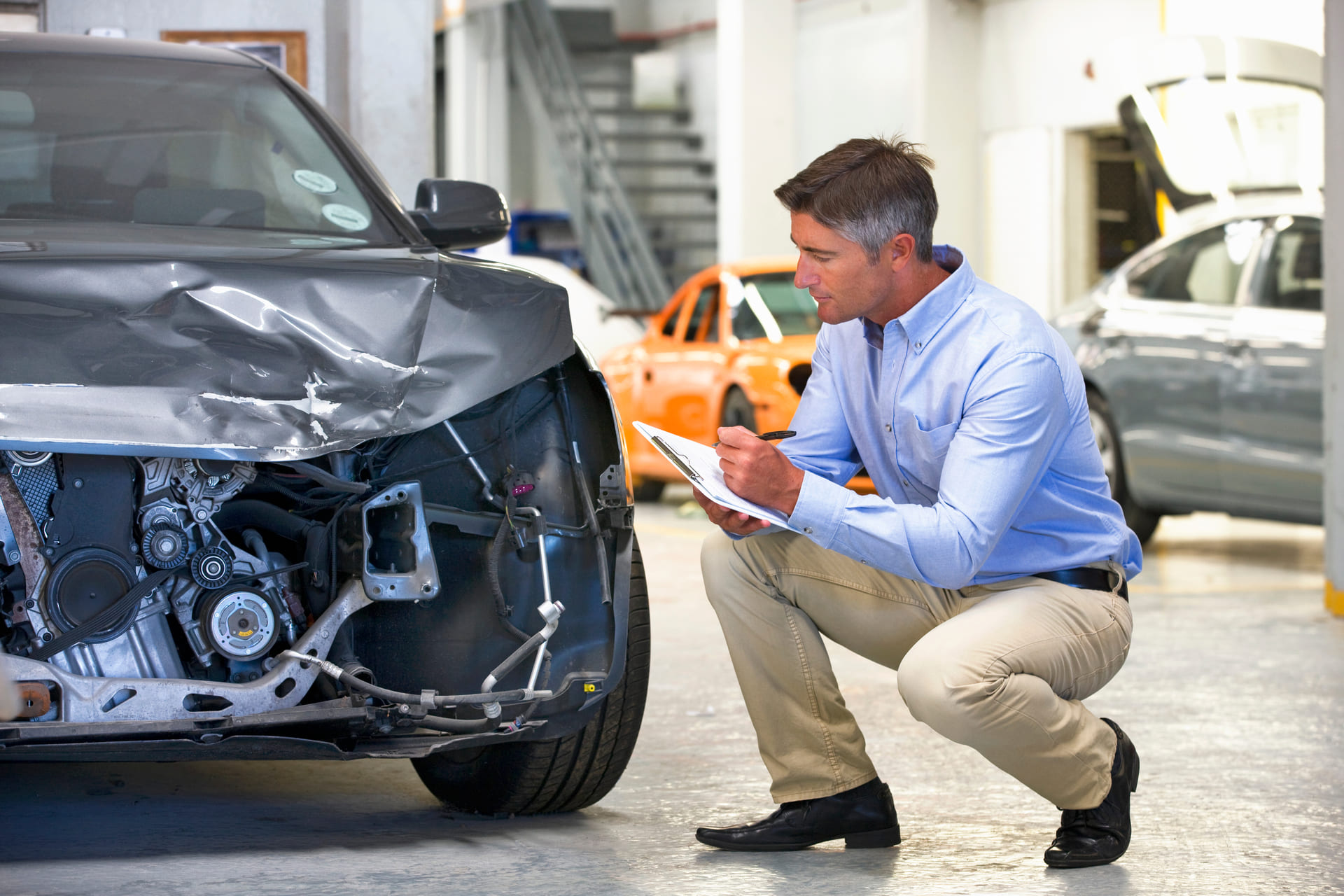 Expert looking at damaged car